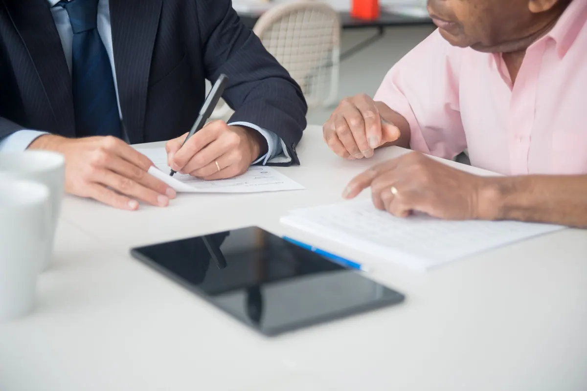 Two people going through figures and documents at a desk